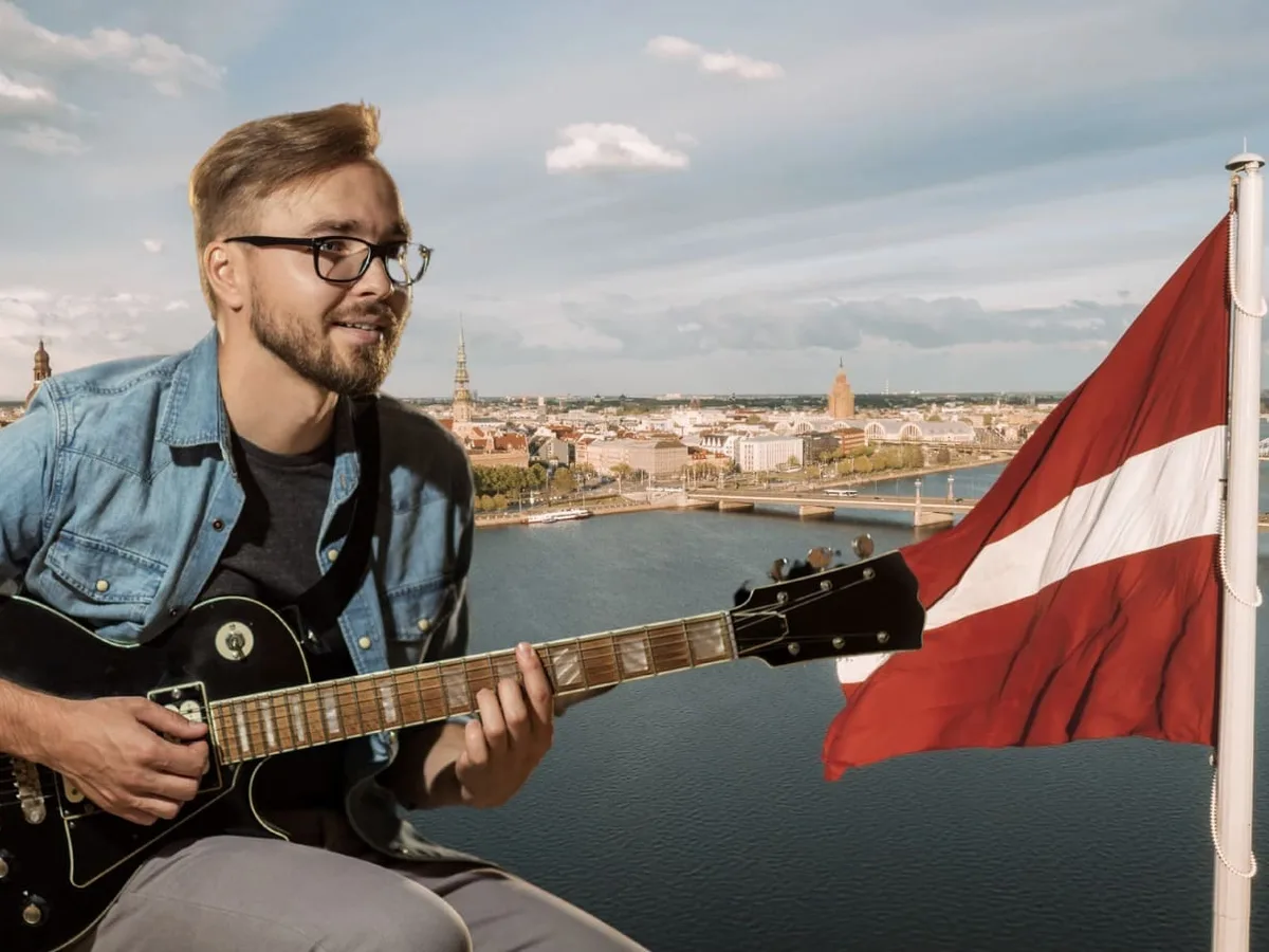 A guitarist playing against the Riga skyline with the Latvian flag